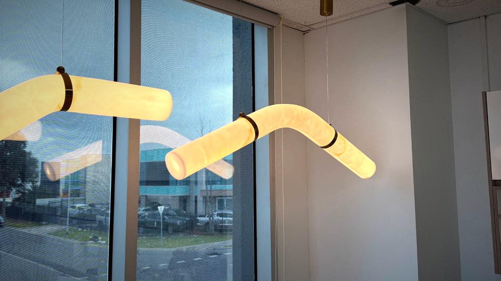 Curved stone pendant lights with brass collars
